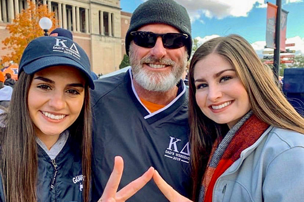 Greek father tailgating with daughter and friend.